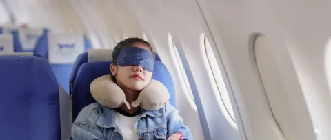Jeune femme qui s'endort en avion lors d'un vol long courrier