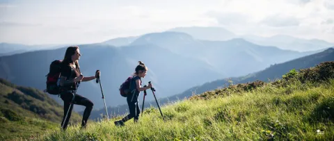 Une maman et sa fille randonnent dans les montagnes