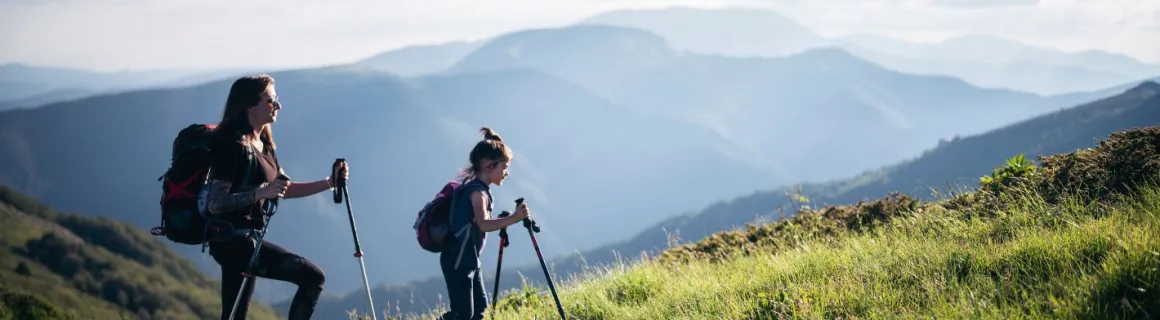 Une maman et sa fille randonnent dans les montagnes